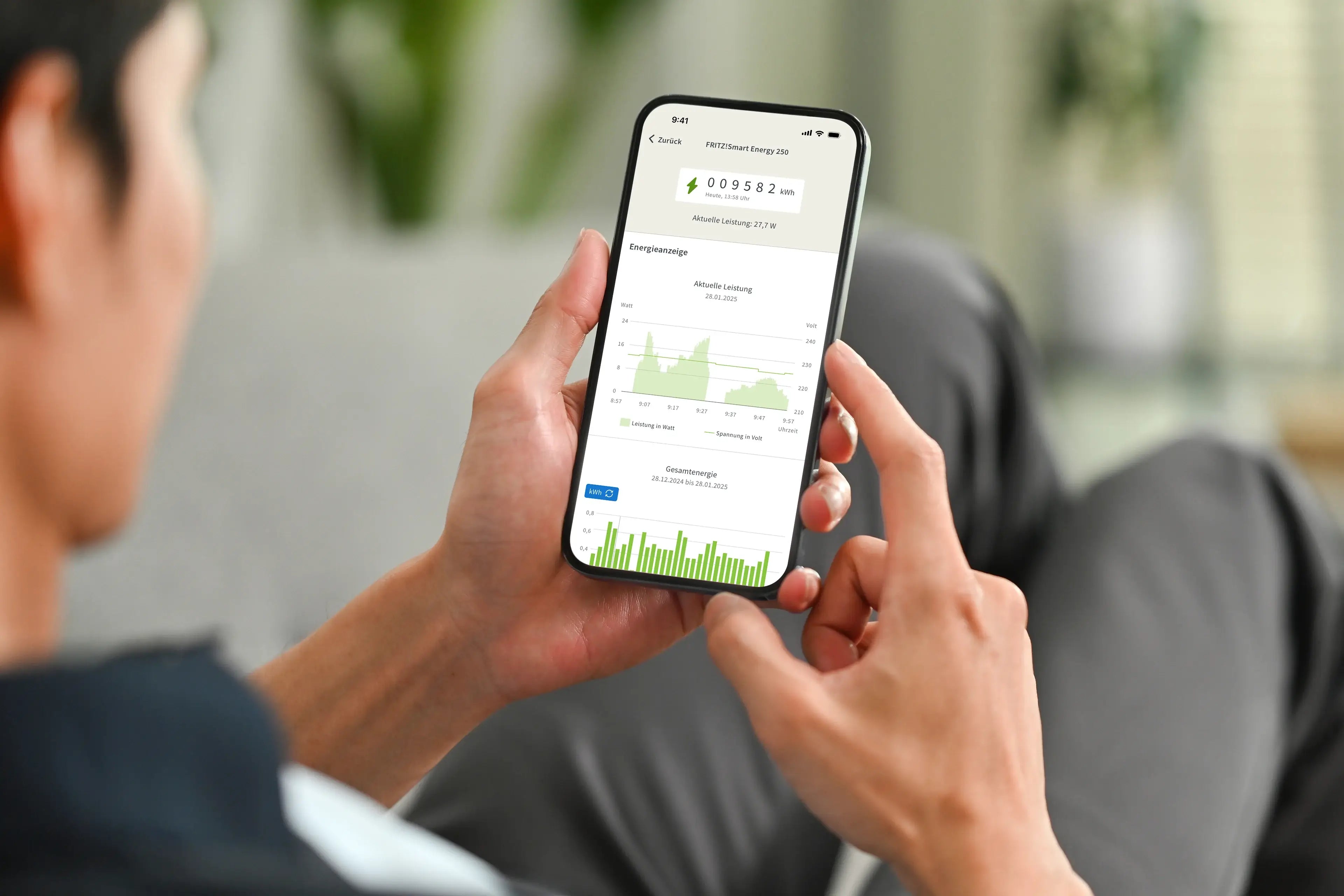 Mann nutzt Smartphone zur Anzeige von Grafiken und Datenanalysen in einem modernen Raum.